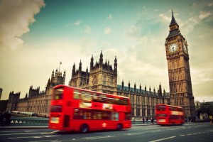 London, the UK. Red bus in motion and Big Ben, the Palace of Westminster. The icons of England in vintage, retro style